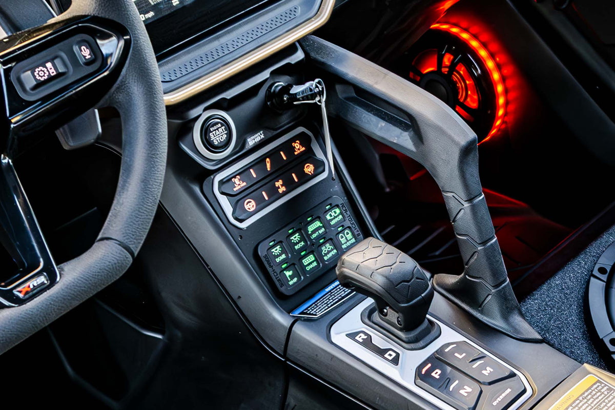 Interior center console of a vehicle with illuminated switch panel and gear shifter