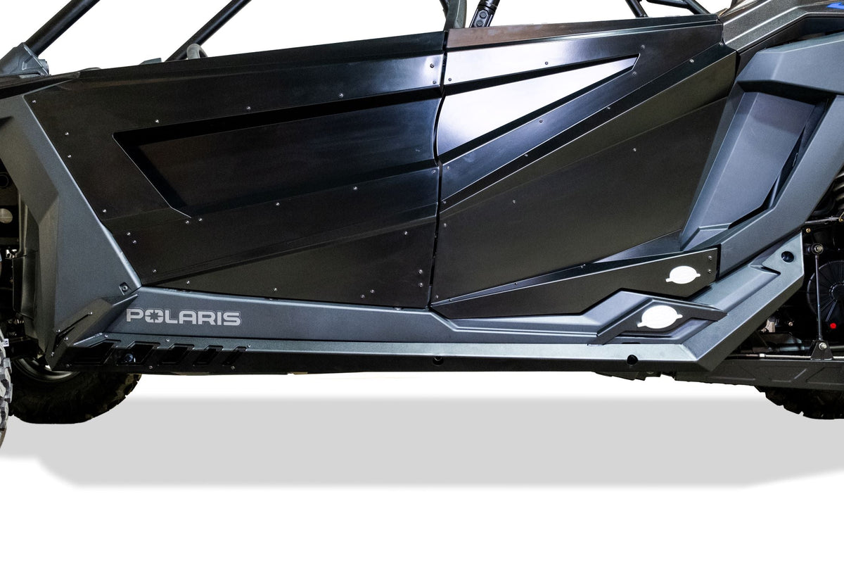 Billet badge and accent plate close-up on Polaris RZR Volt rock sliders