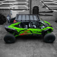 Green off-road vehicle with large tires in a garage setting