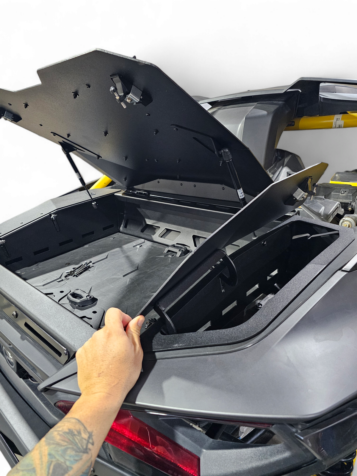 Volt Baja Box lid open on Can-Am Maverick R showing all three separate storage
    compartments and gas strut lid assist mechanism holding lid open hands-free