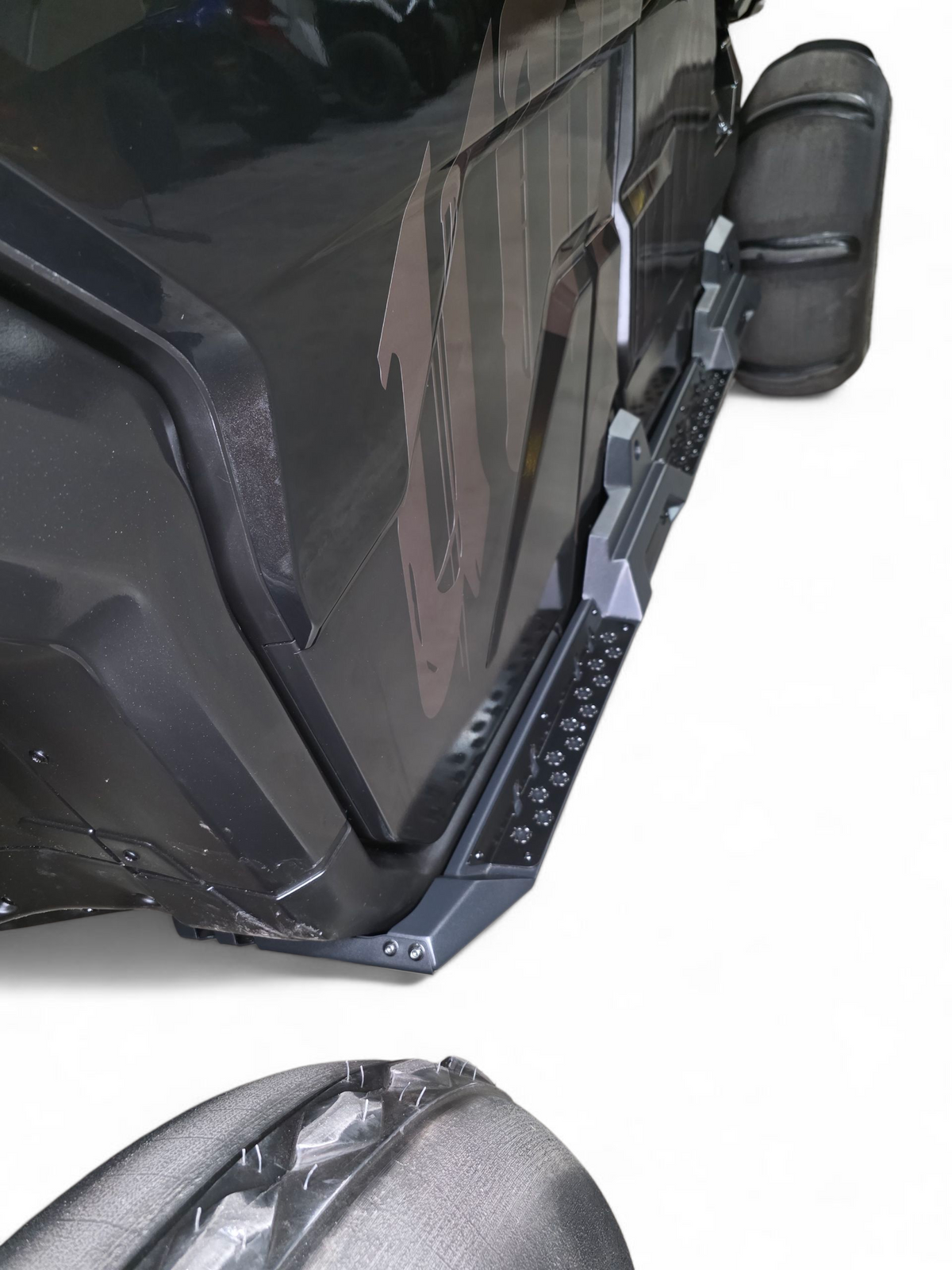 Driver side Volt Rock Steps installed on 4-seat Can-Am Defender showing frame protection