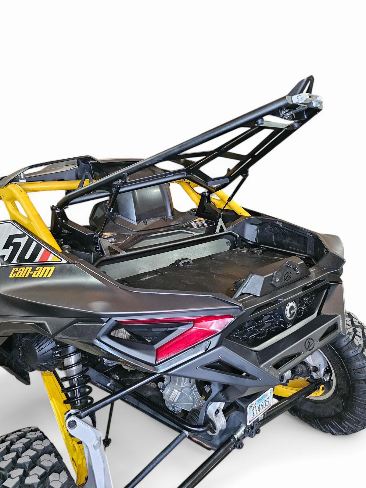 Close-up of dual gas struts on EOD Volt Tire Rack for Can-Am Maverick R showing assistance mechanism and attachment points
