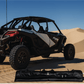 Off-road vehicle on sand dunes with a folded canopy in the foreground