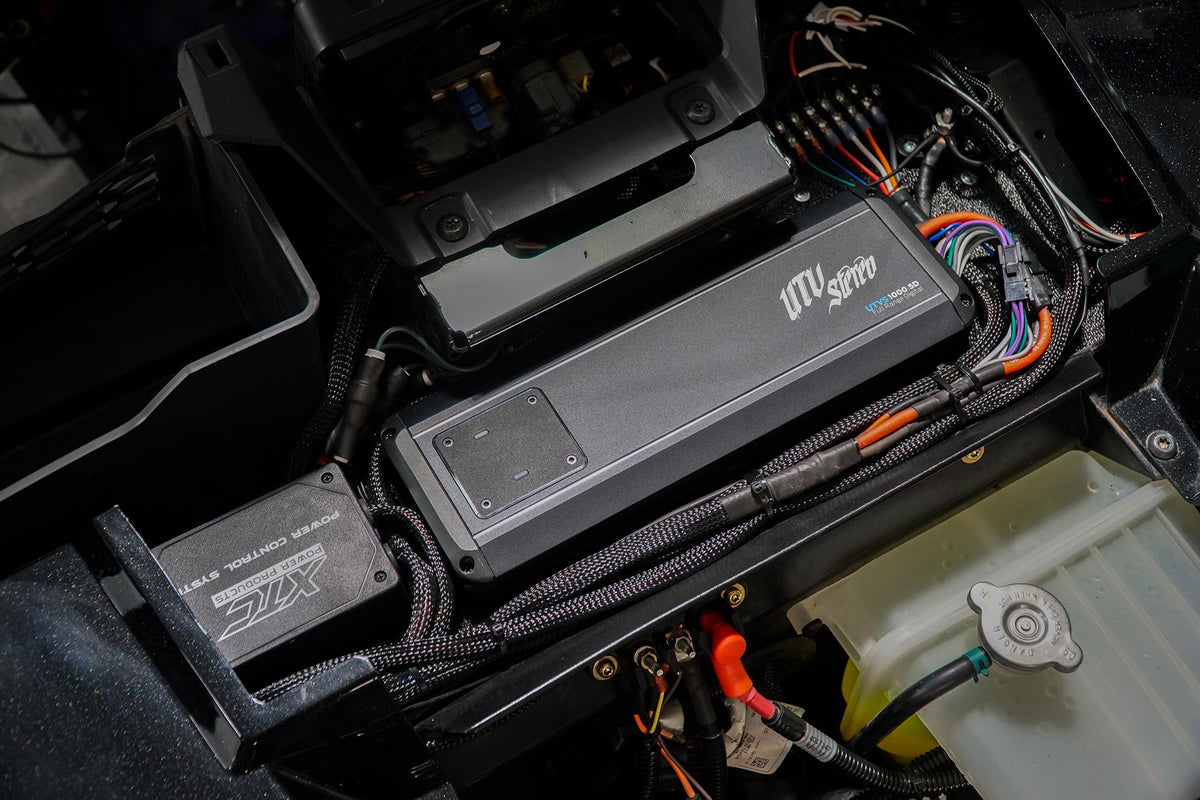 UTV Stereo amplifier and XTC power control system installed in a vehicle engine bay