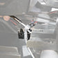 Close up of a metal brake line splitter block installed on a vehicle frame