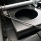 Black subwoofer enclosure box mounted in a vehicle frame