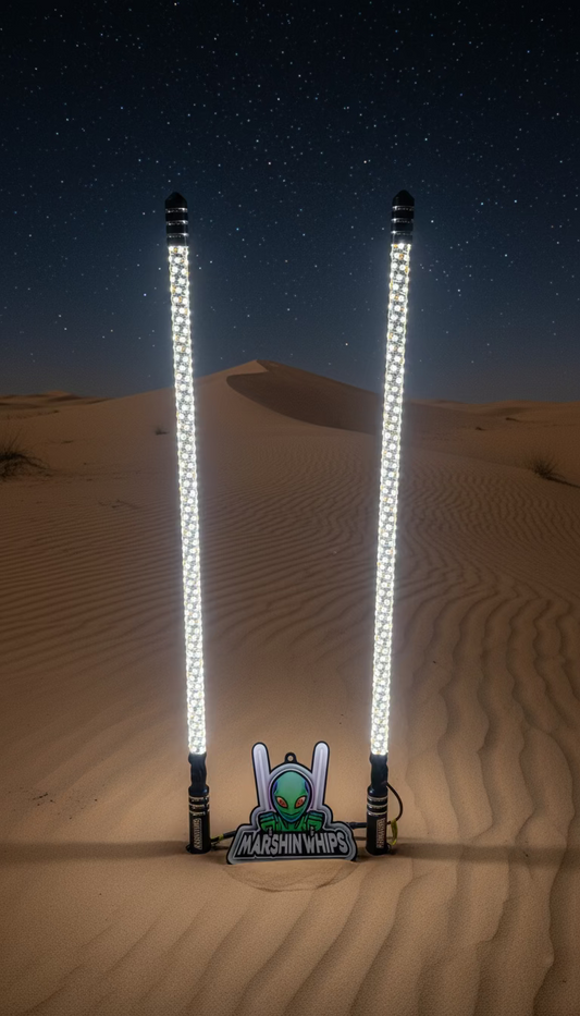 Two Marshin Whips with LED lights in the sand, featuring the Marshin Whips logo.