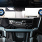Two circular marine speakers with blue LED lighting mounted on the roll cage of an off road vehicle