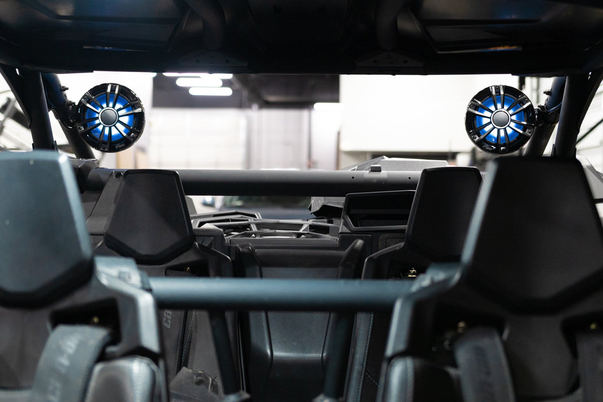 UTV Stereo speakers with blue LED lighting mounted on the roll cage of an off road vehicle