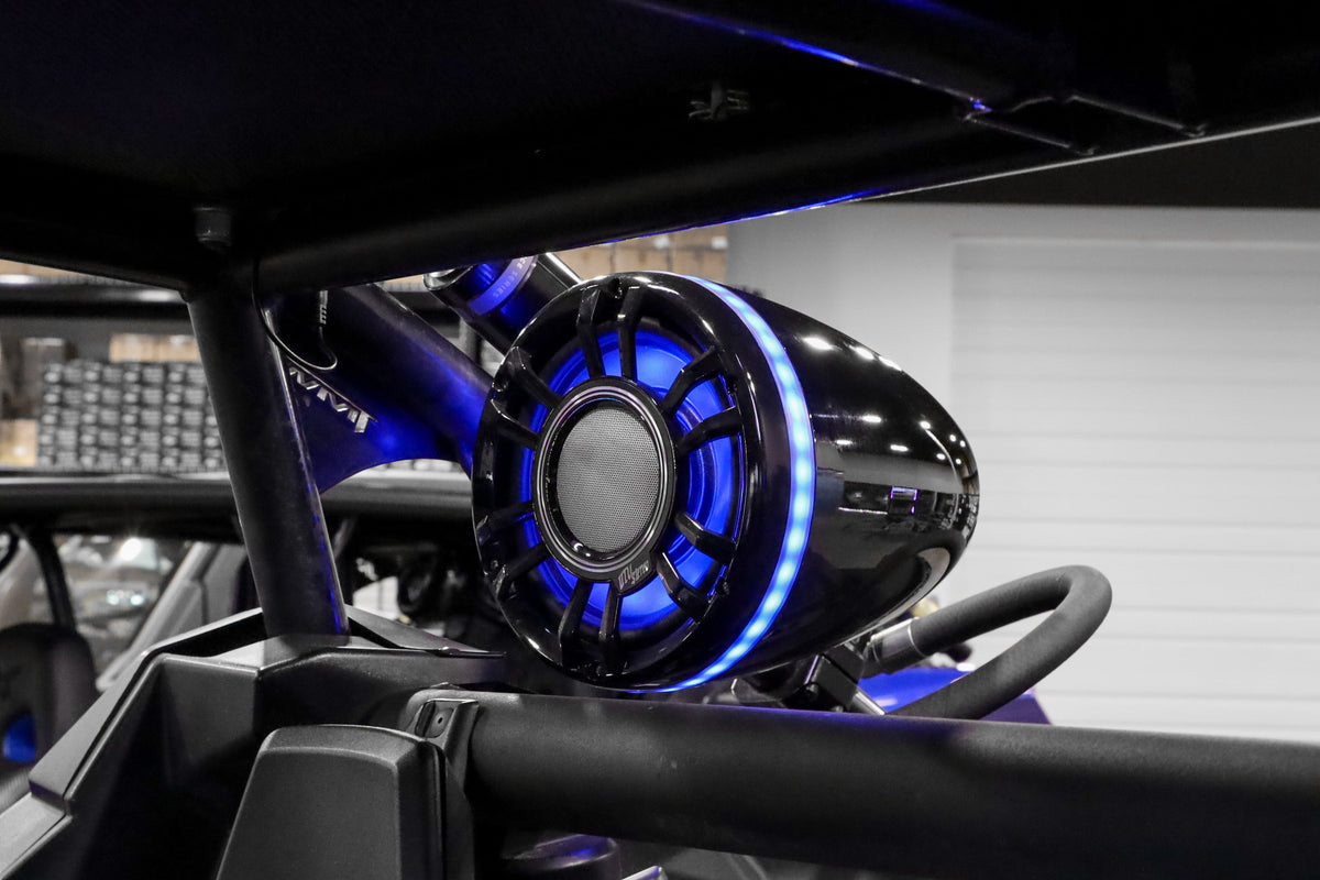 UTV Stereo black pod speaker with blue LED ring mounted on vehicle roll cage