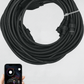 Coiled black cable for rock lights with smartphone displaying the PRO RGB App used.