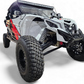 Black anodized Can-Am Maverick X3 billet front winch bumper with round lights mounted showing forward lighting setup