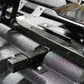 Black metal trailer hitch receiver mounted on textured vehicle chassis