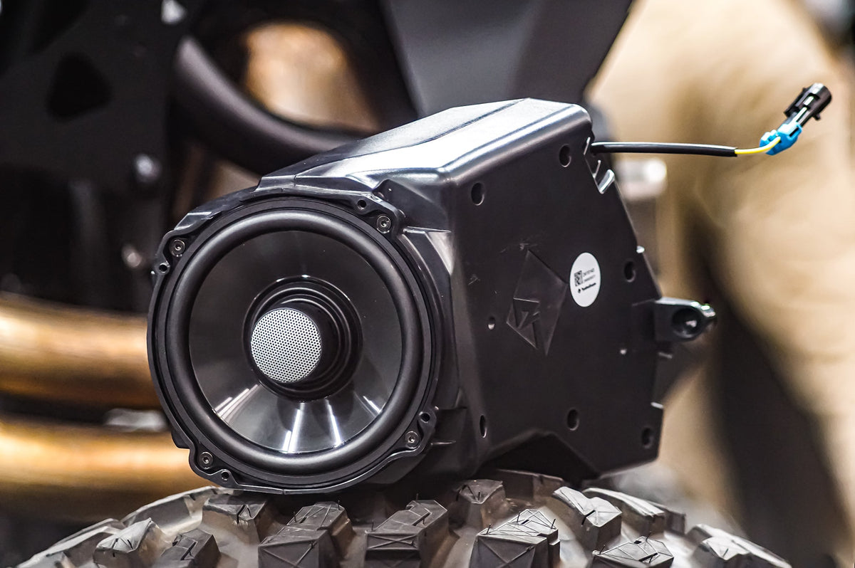 UTV Stereo speaker enclosure with integrated speaker resting on a tire