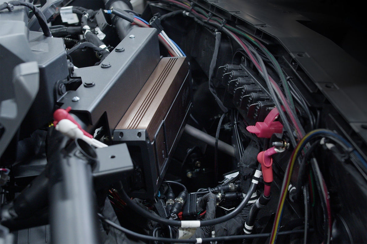 UTV Stereo amplifier installed in a vehicle engine bay with wiring