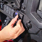Hand adjusting a UTV Stereo volume knob mounted on a vehicle dashboard