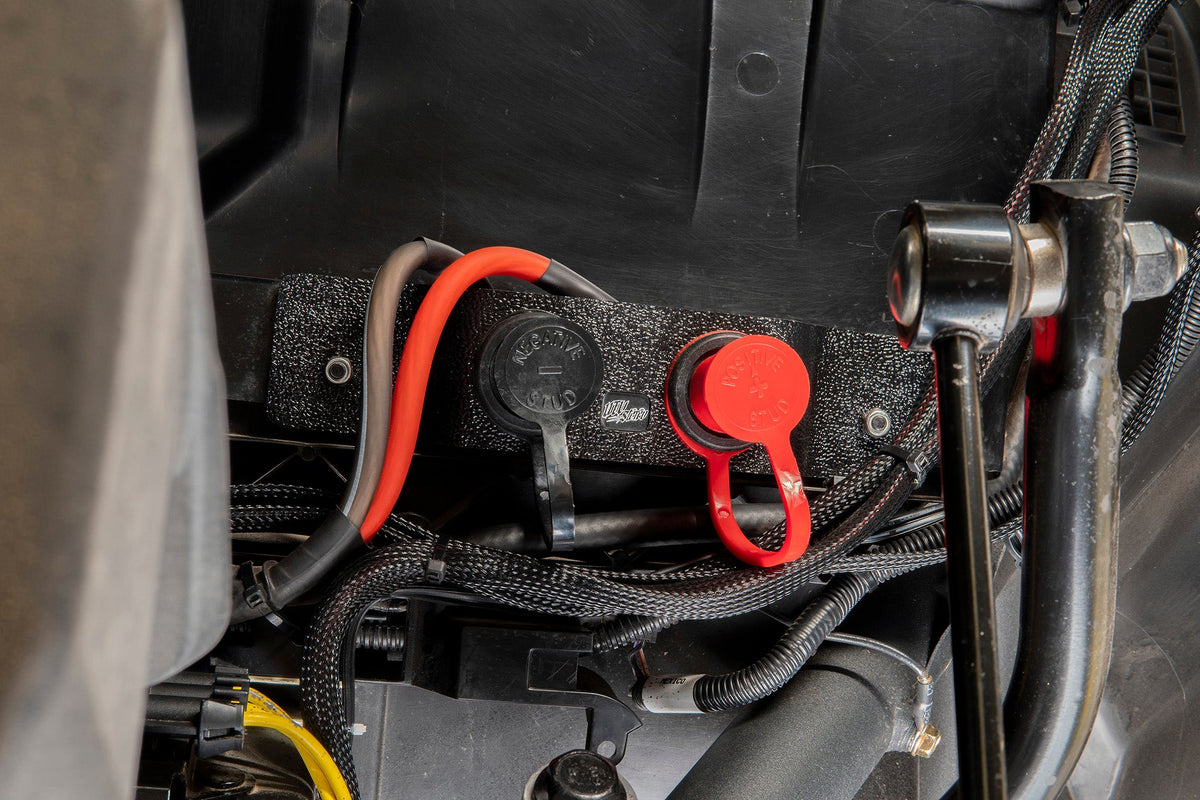 UTV Inc battery terminal stud kit with red and black protective caps installed on vehicle frame