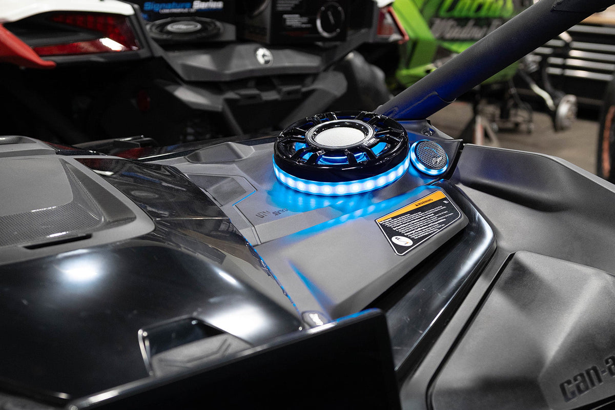 UTV Stereo speaker with blue LED ring light installed on a vehicle dashboard
