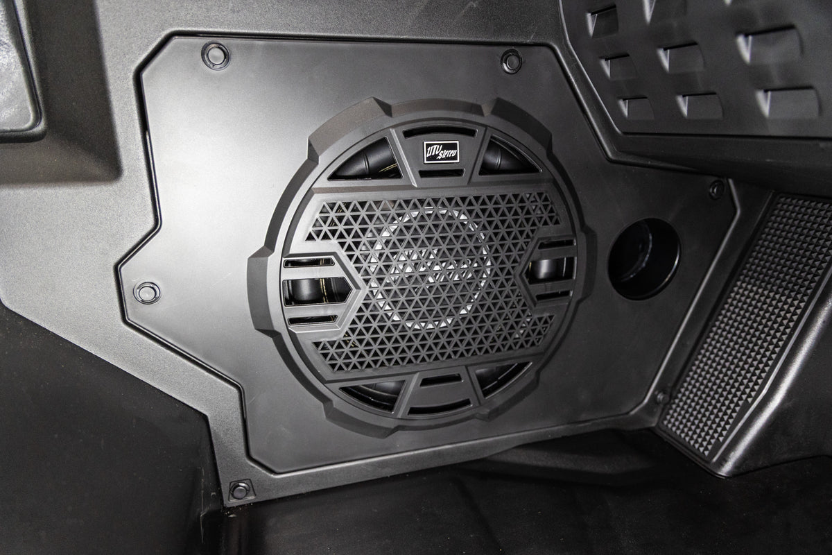 UTV Stereo subwoofer mounted in a black vehicle interior panel
