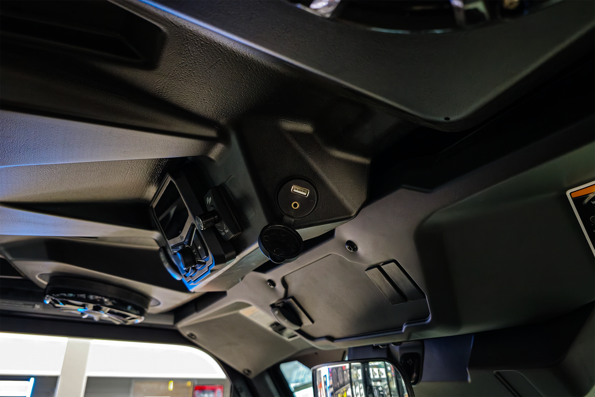 USB port and audio jack mounted on the overhead console of a vehicle cabin